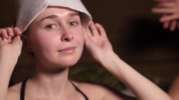 A Girl Puts on a Hat for the Bath