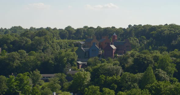 Aerial View of Colonial Architecture Style Buildings Amongst Trees on a Hill