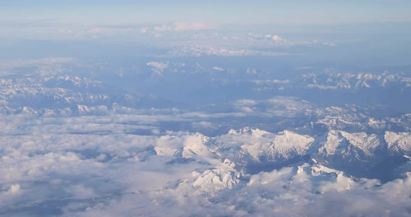 Aerial View From Airplane Window On Snowy Top Of Tatra Mountains In Summer Day. High Attitude