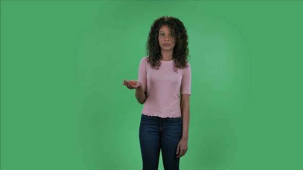 Portrait of Beautiful African American Young Woman Is Looking at Camera and Negatively Waving His