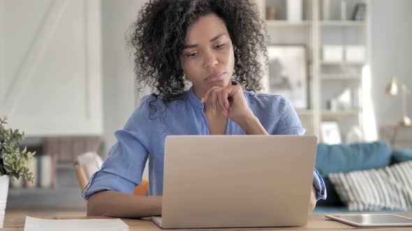 Pensive African Woman Working on Laptop