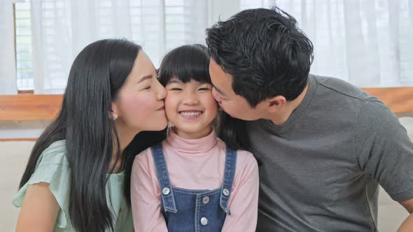 Portrait of Asian happy family parents spend time together with daughter enjoy activity at house.