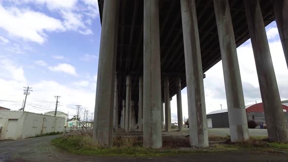 Passing under a concrete overpass from left to right on a partly cloudy spring day after a brief rai