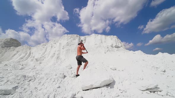 Muscular man on the background of white mountain.