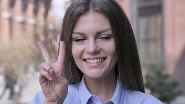 Victory Sign by Positive Young Woman