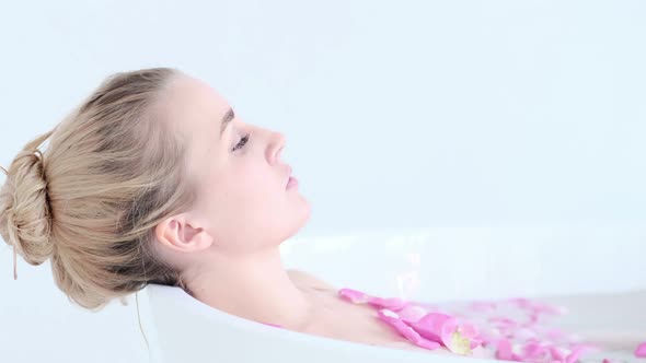 Beautiful Sexy Caucasian Blonde Girl In Bikini Lying In Flower Bath In Resort Day Spa Salon