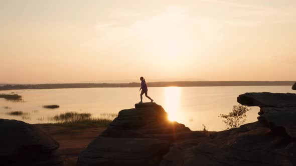 A Girl Does Fitness on a Hill at Sunset