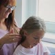 Mother Braids Daughter's Hair By the Window - VideoHive Item for Sale