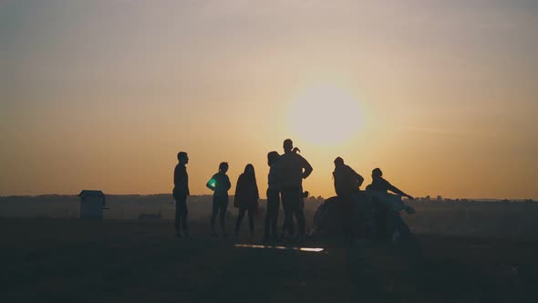 Silhouettes of Tourists Spending Time By Tent at Sunset