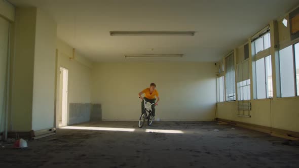 BMX rider in an empty warehouse