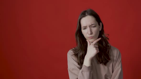 Portrait of a Thoughtful Young Woman with Long Hair Thinking Intensely Pondering a Solution to a