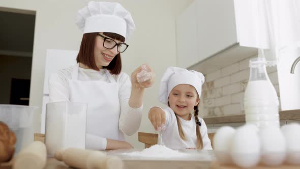 Overjoyed Mom Have Fun Sprinkling Flour and Baking Cookies or Pastries with Cute Preschooler Girl