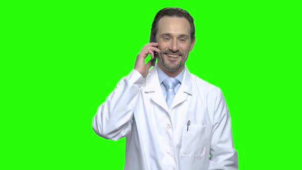 Smiling Pleasant Mature Doctor Having a Phone Cal