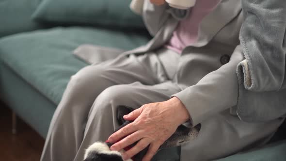 Beautiful Mature Woman with Gray Hair and a Short Haircut is Relaxing Sitting on the Sofa