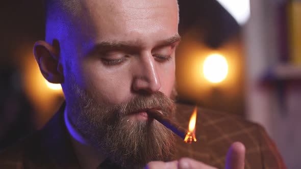 Rich Young Caucasian Businessman in Suit Smoke a Cigar While Sitting Alone in Dark Room, Enjoy