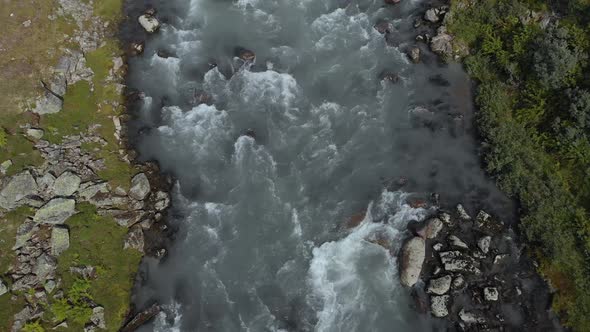 Glacial meltwater river fast flowing downstream in summer, Norway, aerial view
