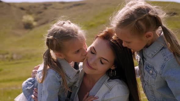 Happy Young Mother Hugs Her Twin Daughters Field Green Grass