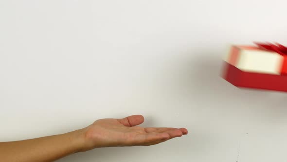 Woman hand holding a present for Merry Christmas. New Year and Christmas gifts in bright boxes