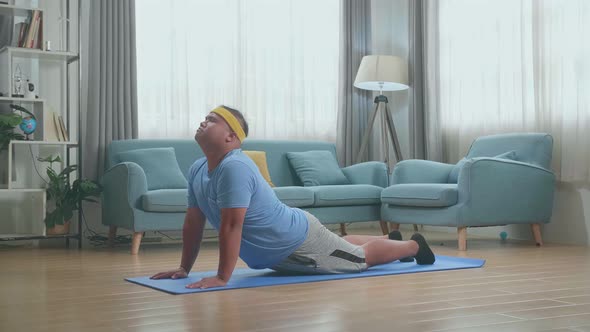 Fat Asian Man Doing Yoga By Upward Facing Forward Bend On Mat At Home