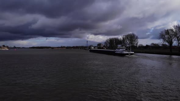 Clouded Sky Over Quiet Oude Maas River With Ship Traveling Near Puttershoek, Netherlands. - Wide Sho