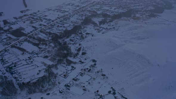 View of the Russian Village Through the Clouds in Winter at Dusk