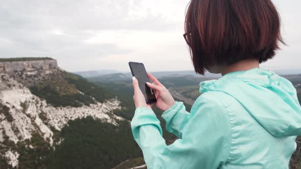 Traveler Woman Using Smartphone with GPS App in Mountains