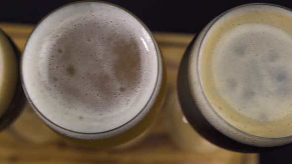 Top View of the Glasses of Fizzy White and Black Wine on a Wooden Wine Flight.