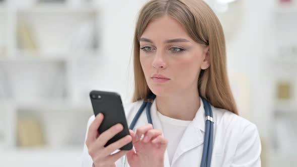 Portrait of Focused Young Doctor Using Smartphone