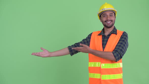 Happy Young Bearded Persian Man Construction Worker Showing Something