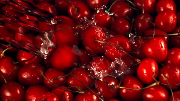 Super Slow Motion on the Fresh Cherry Falls a Jet of Water