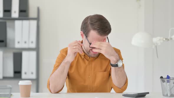 Young Man Having Headache in Office