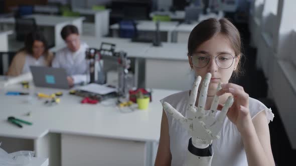 Close Up View of a Young Lady That Looks on the 3D Printed Hand