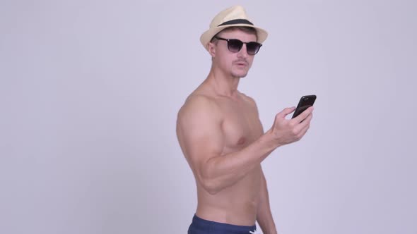 Muscular Bearded Tourist Man Looking for Directions with Phone