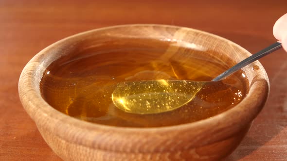 Taking Honey By Using Spoon in Wooden Bowl, Flowing Down