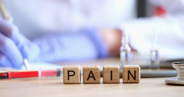 Wooden Cubes with the Inscription Pain