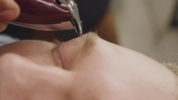 Close Up of Shaving Eyebrows with Trimmer