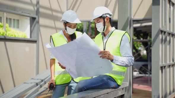 Asian workers man and woman wearing protective face mask onsite and work during Covid 19 pandemic.