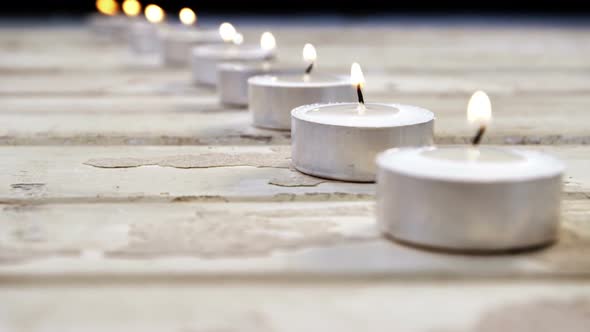 Burning candles on wooden plank