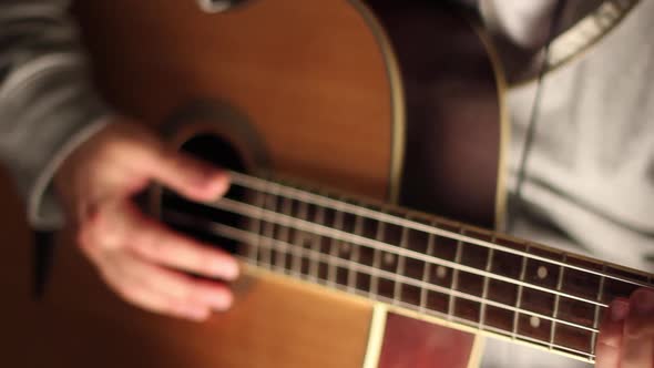 A young man plays his bass guitar.