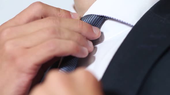 Businessman In Suit Adjusts His Tie