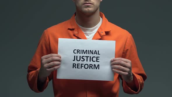 Criminal Justice Reform Phrase on Cardboard in Hands of Caucasian Prisoner