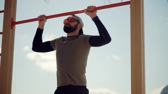 Fitness Sport Street Workout. Muscle Up In Public Gym. Healthy Man On Pull-up Bars Exercising.