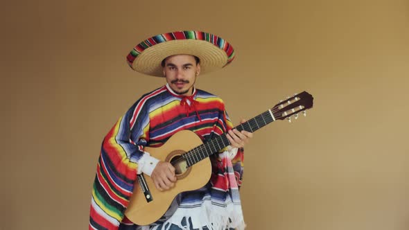 Young Mexican In National Costume Playing Guitar