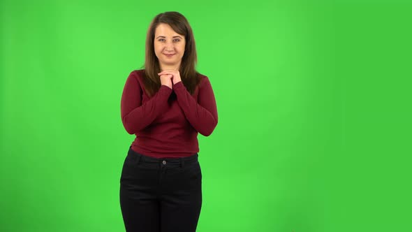 Pretty Girl Looking with Tenderness with Folded Arms in Front of Her. Green Screen