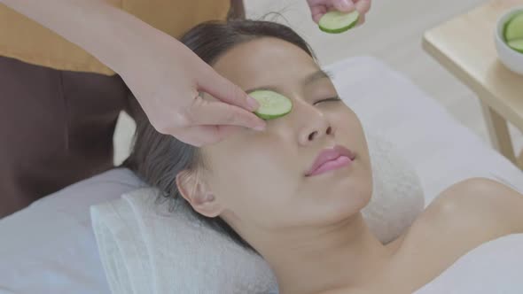 An young Asian woman lying down on a massage table in a spa at the resort during holiday.