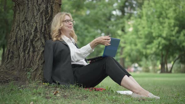 Portrait of Happy Beautiful Middle Aged Caucasian Woman in Eyeglasses Messaging Online Closing