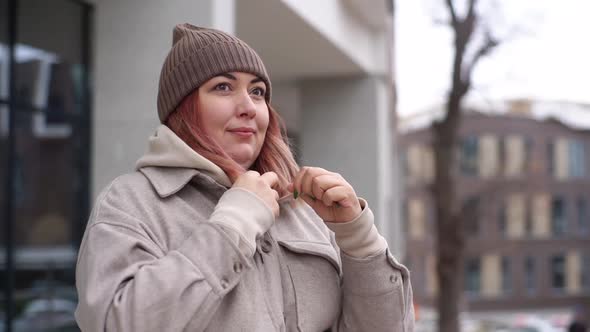 Closeup of Frozen Overweight Woman Tying Her Hoodie Laces Standing Alone in Cold Autumn Day Waiting