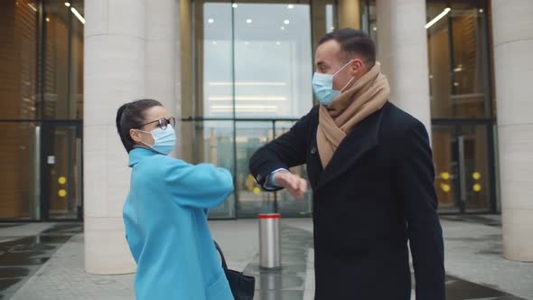 Business People in Safety Mask Greeting with Bumping Elbows Outdoors During Covid19 Pandemic