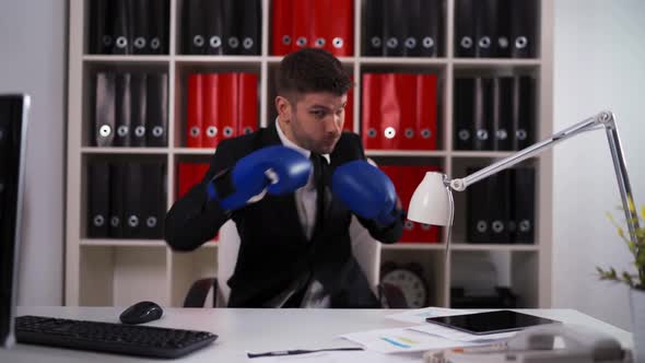 Businessman Wearing Boxing Gloves in Office