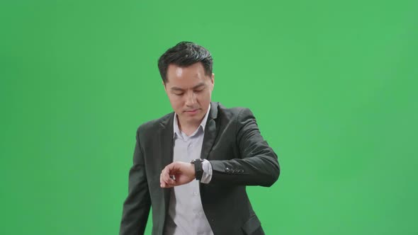 Asian Business Man Walking While Looking At Watch And Run On Green Screen Chroma Key